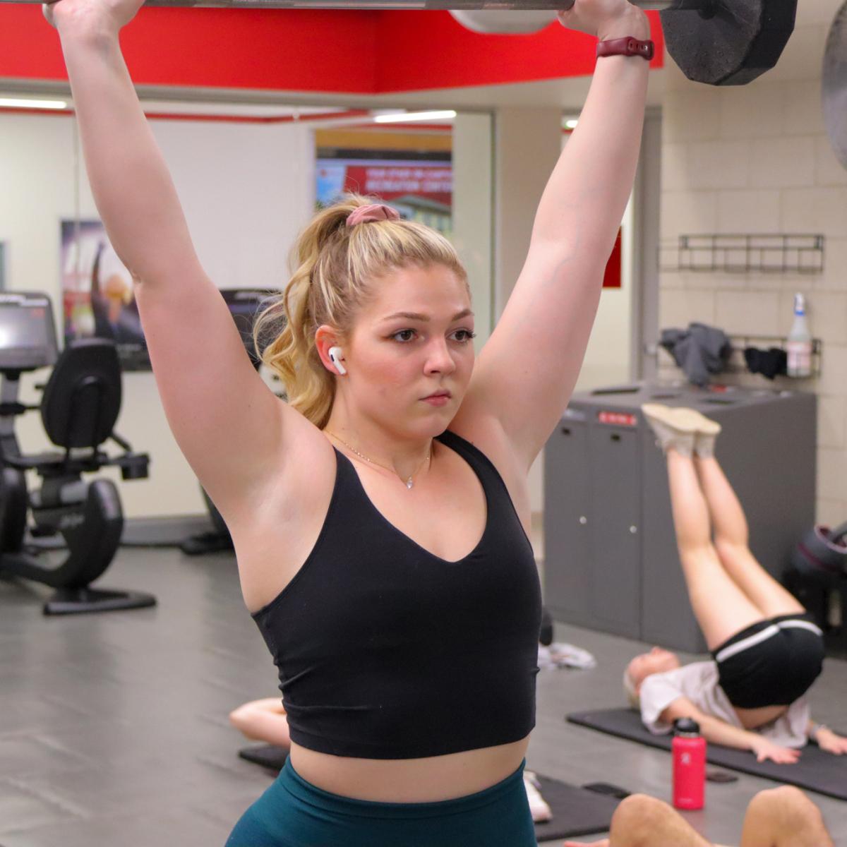 A woman lifts weights in the Strength Training and Condition Room